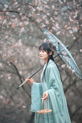 一位穿着蓝色和服的女士拿着雨伞