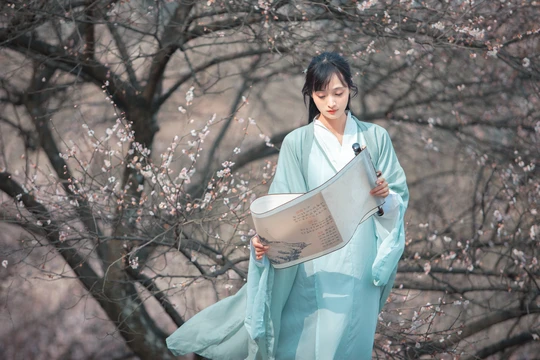 一位穿着蓝色和服的女人穿过树丛
