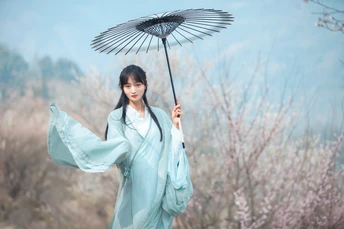 一位穿着蓝色和服的女人拿着雨伞