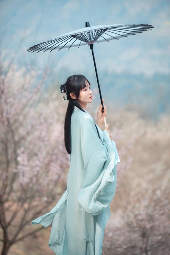一位穿着蓝色和服的女性拿着雨伞