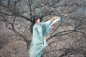 一位穿着蓝色和服的女人站在雨伞下