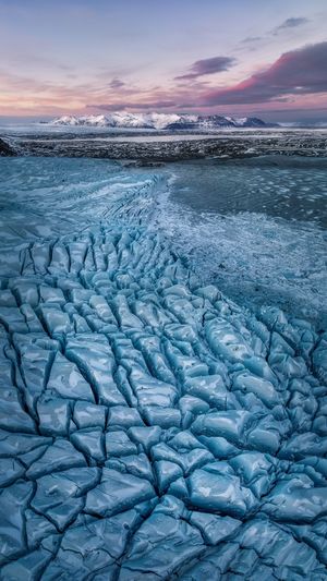 夕阳下的冰川上的蓝色冰
