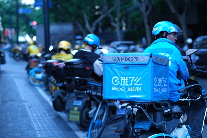 骑着自行车穿蓝盔的警察在一条城市街道上