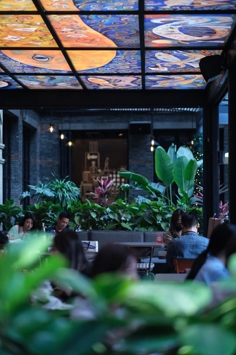 带有植物吊顶的餐厅 人们坐在桌子旁