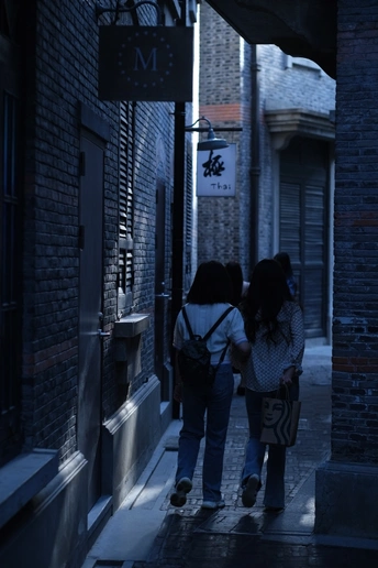 夜晚的黑暗小巷 一对年轻人在人行道上行走。