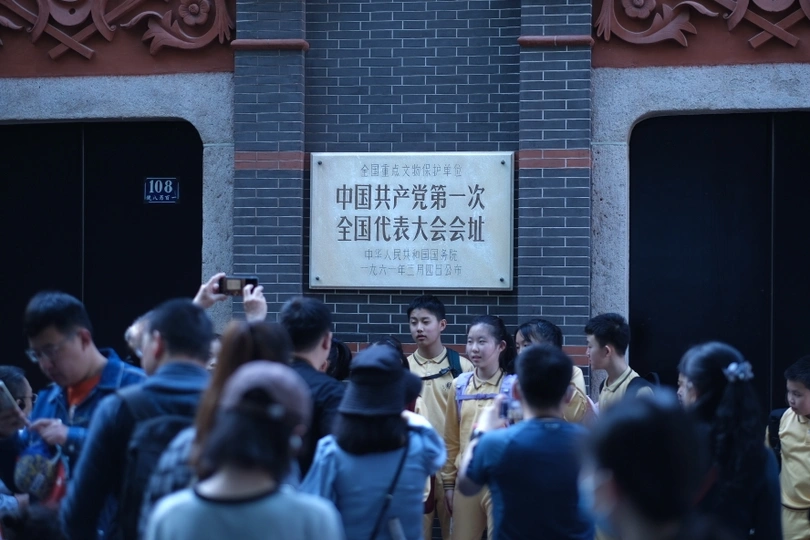 人群站在建筑物的标志前排队拍照