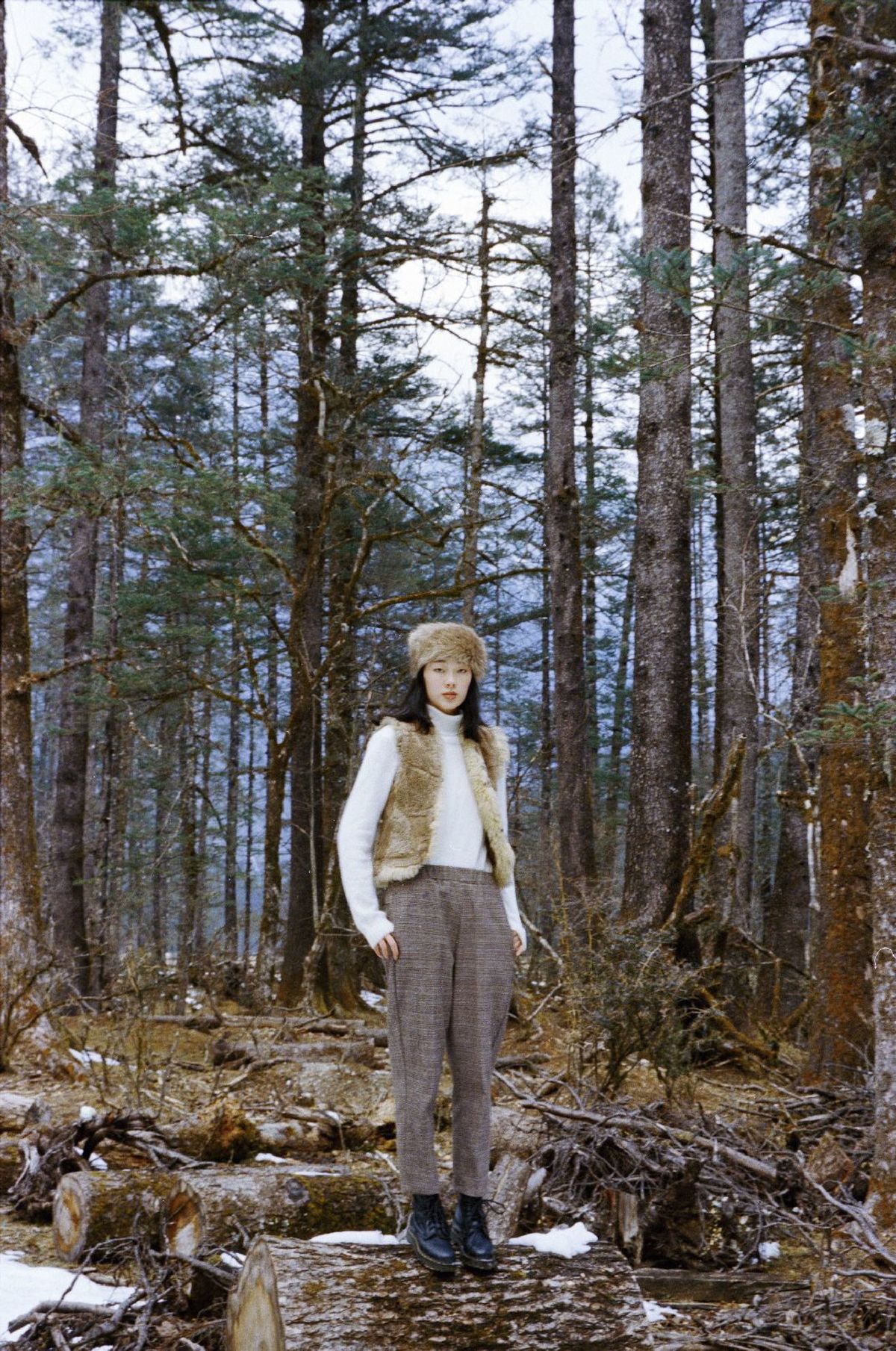 戴帽子的人在森林中 地上有雪 树上有雪。