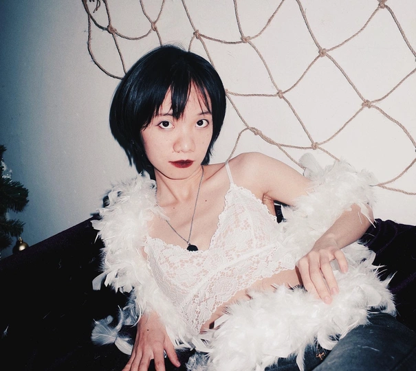 一个坐在覆盖着羽毛的沙发上的年轻女子