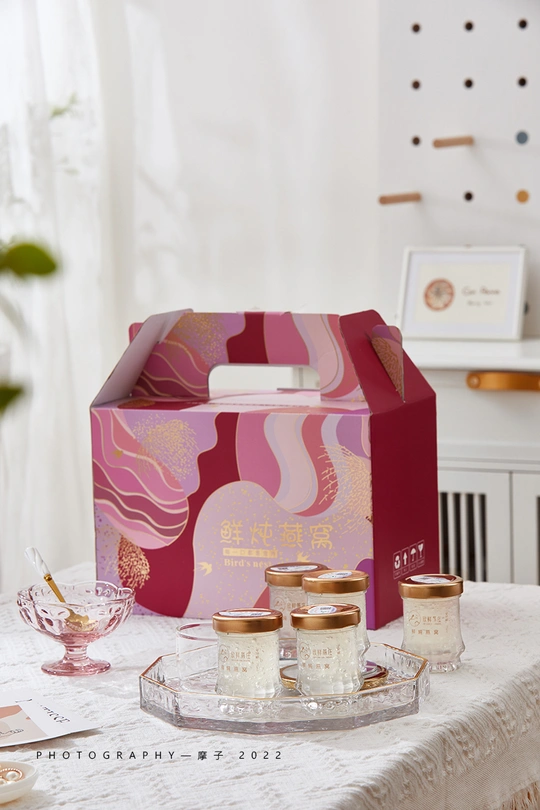 蜡烛托着的桌子 旁边有一个粉色盒子