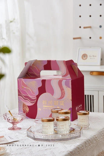 蜡烛托着的桌子 旁边有一个粉色盒子