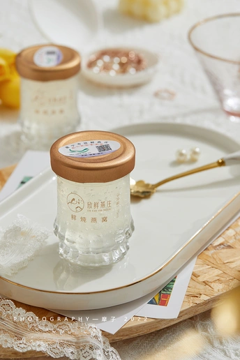 一个白盘子顶部放了一个小罐子和一把勺子