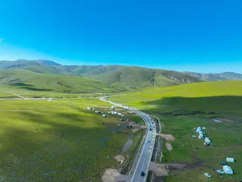 中部绿色山谷中的蓝色山脉的高速公路 aerial shot