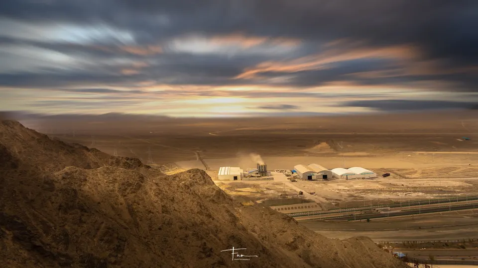 一片沙漠 天空中有山丘、山脉和云朵。