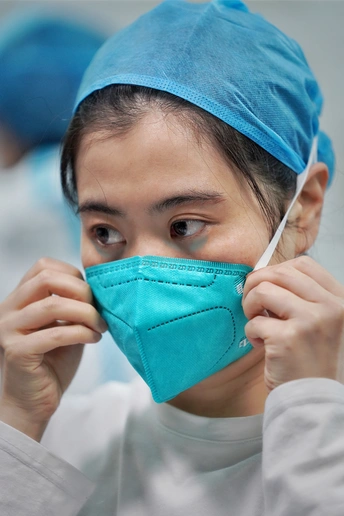 一位戴着蓝色外科口罩的年轻女子