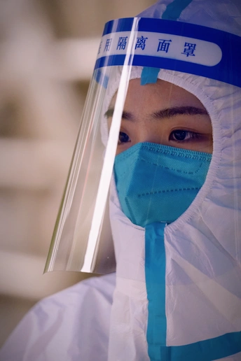 一个穿着蓝色防护服和塑料口罩的人