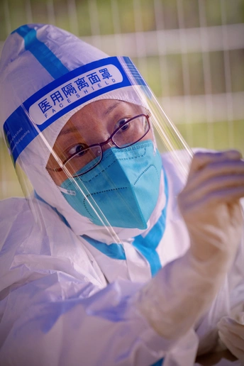 一名身穿蓝色防护服和医用口罩的男子