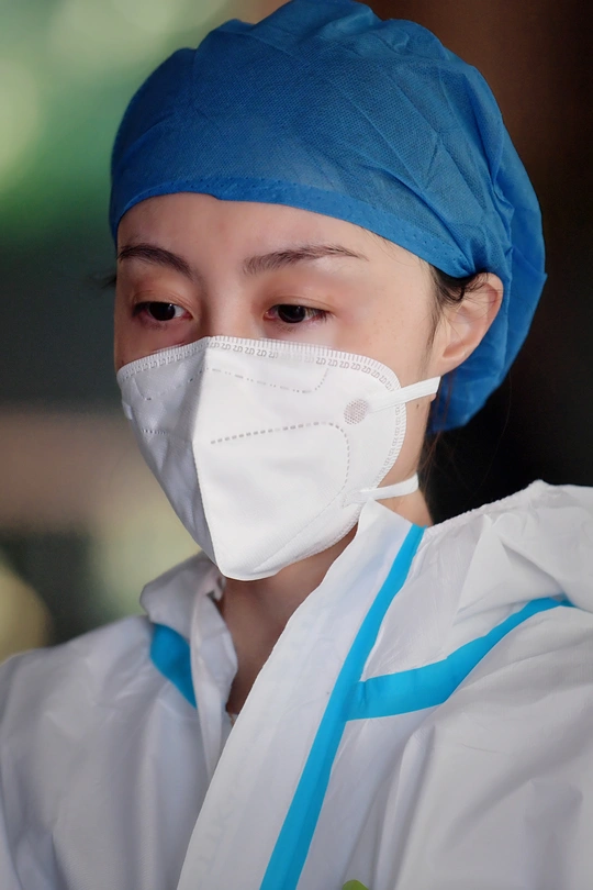 戴着外科口罩、穿着医生或外科医生制服的年轻女子