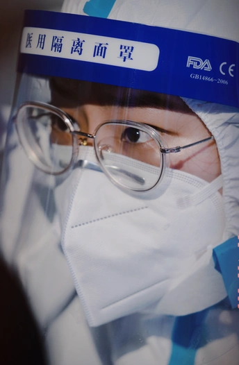 一个人戴着医用口罩和眼镜的照片