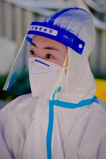 一位女士穿着塑料雨衣 头上戴着蓝色风帽 头上带着塑料帽