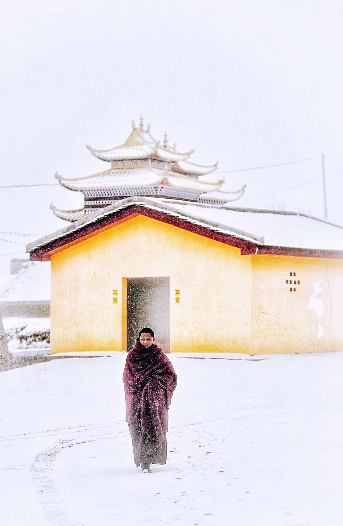 一个穿着皮草大衣的男人穿过雪地经过一栋大楼