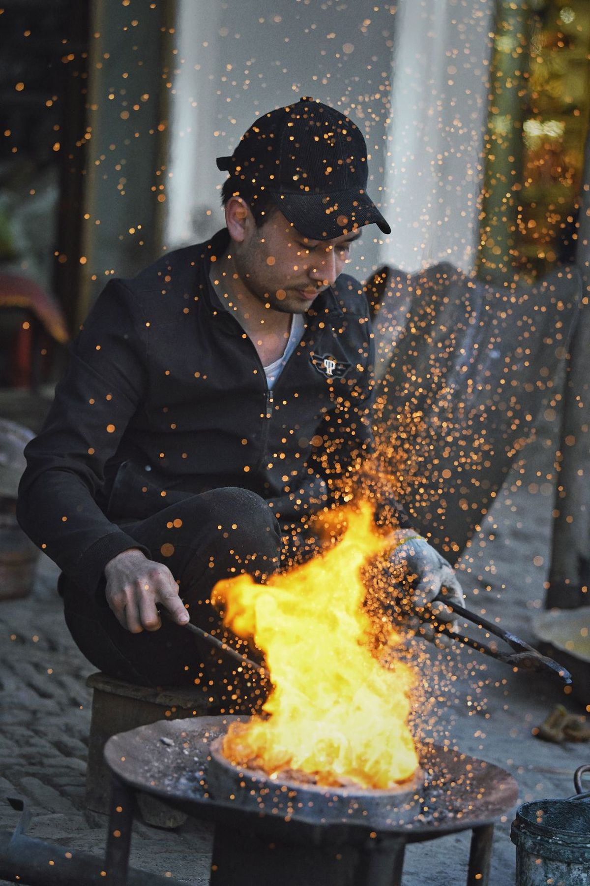 一个用锤子塑造热金属成火焰的男人