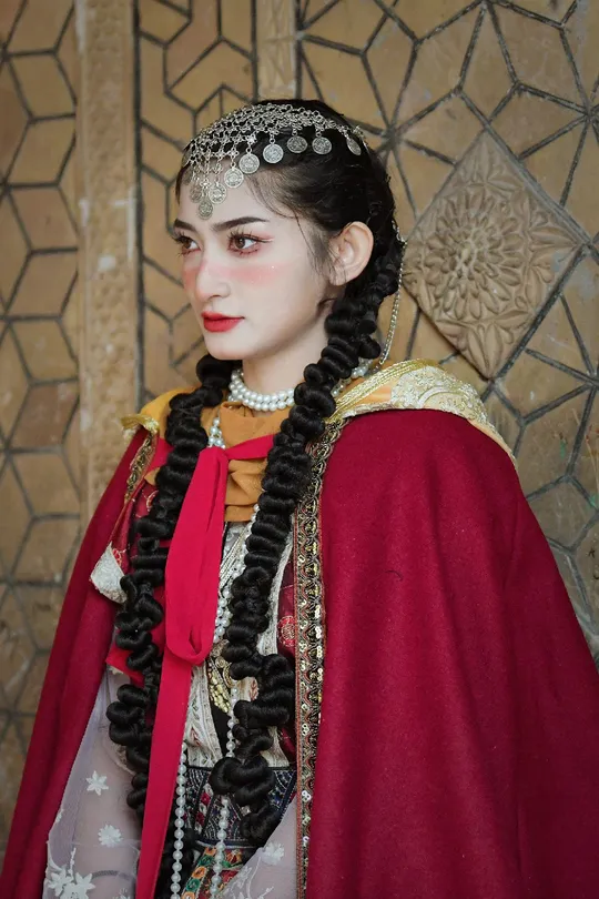 一位穿着传统服装的女孩穿着一件红色裙子