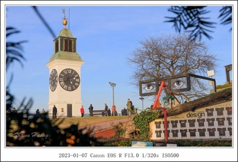 旁边有一棵高树的白塔 旁边有一座大钟