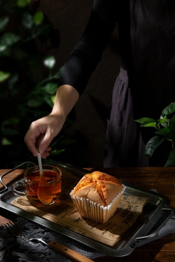 一个人把手放在托盘上 托盘上放着一杯茶和一些食物