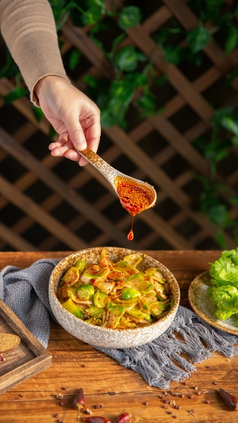 勺子手从木桌上的一碗菜中舀出一些酱汁 上面有生菜。