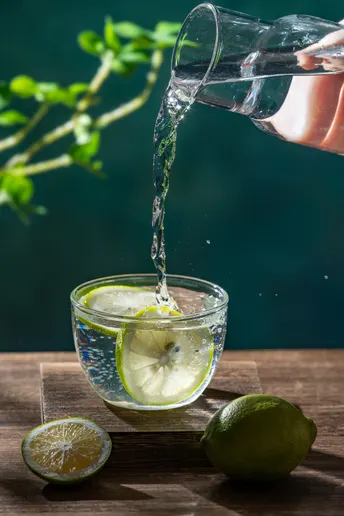 倒入带有柠檬和黄柠檬的玻璃杯中的水