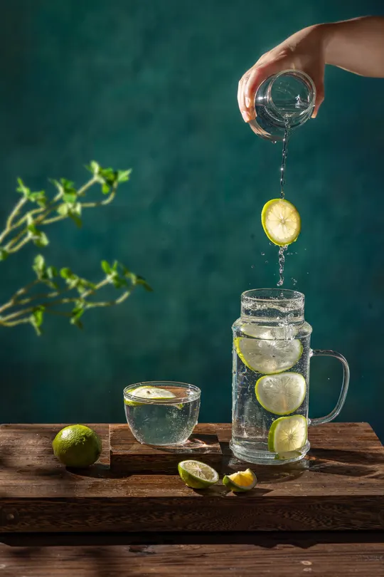 一杯水 柠檬  lime 和黄瓜放在桌子上