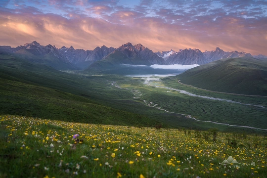 夕阳下美丽的山峦 草地上的野花 山谷中的河流。