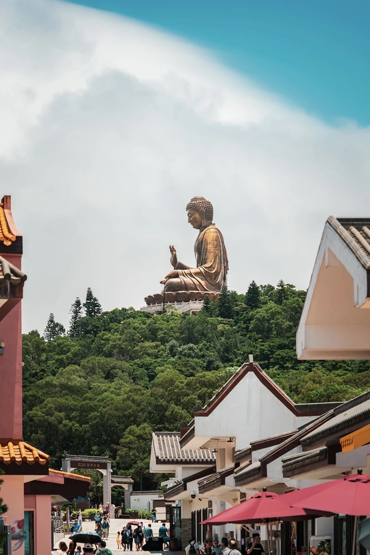 山顶上有一座大型雕像 人们坐在遮阳伞下