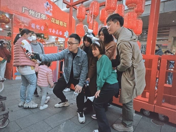 一群人在唐人街的中国灯笼前拍照 照片由<人名>拍摄。