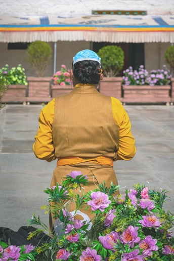 一位戴黄帽子的女人坐在一位有花的男人旁边