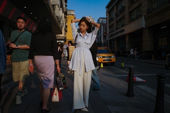 一个穿白色连衣裙的女人站在人行道上