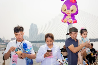 游客们看着手机 一家人拿着玩具