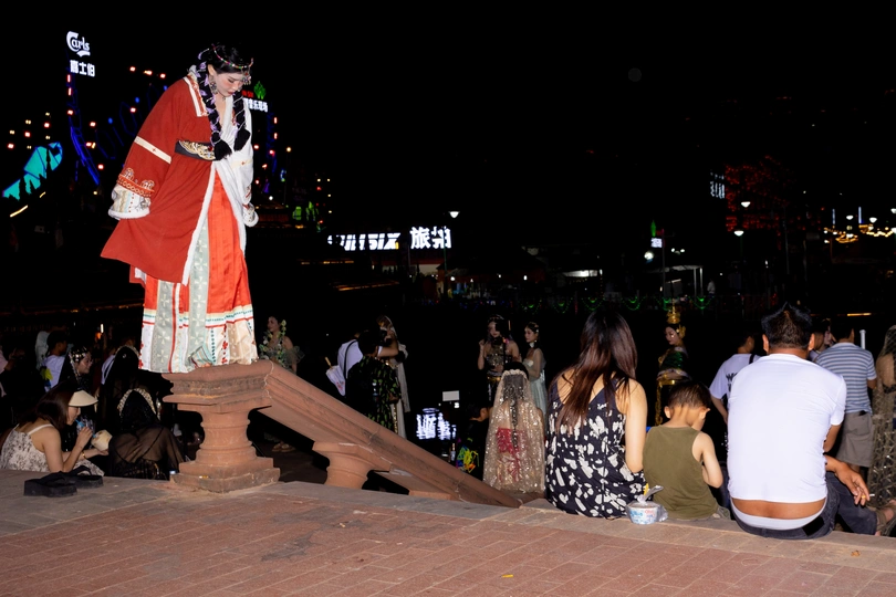 一个夜晚的节日舞台上站着一个男人的雕像