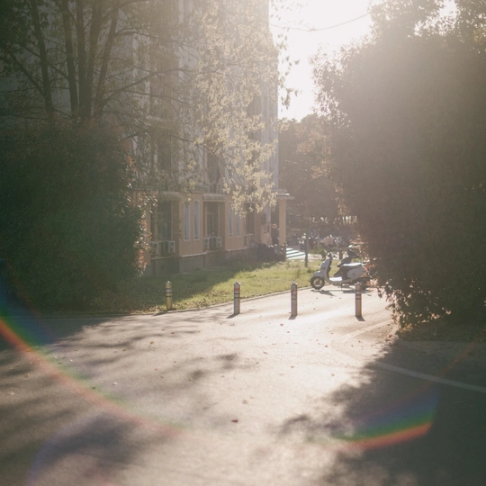 一条街道 两边停满了汽车和摩托车。