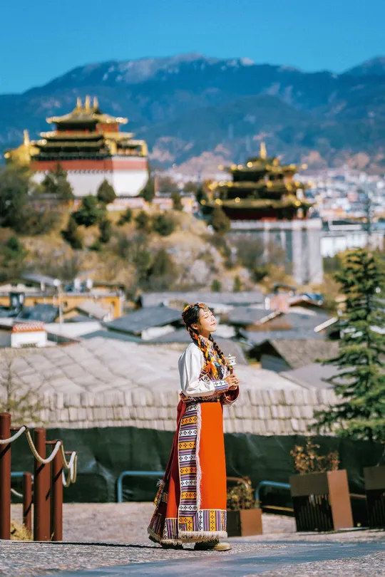 一位穿着传统服装的年轻女子站在城市前面