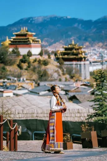 一位穿着传统服装的年轻女子站在城市前面