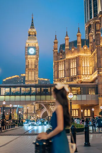 站在一座大型建筑前的钟楼上的女人在夜晚