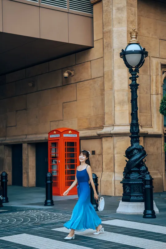 一位穿着蓝色连衣裙的女人穿过街道