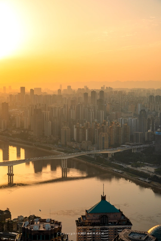 太阳落在一座大城市的上空 这座城市有一条河 天际线上有建筑物