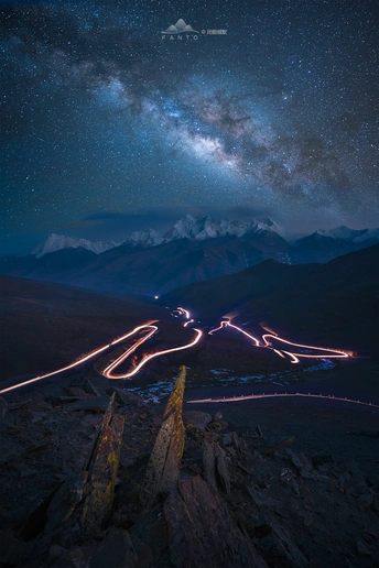 夜空中的恒星长时间曝光照片和来自公路上的光迹