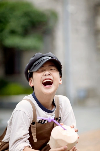 一个戴帽子的小男孩手里拿着一个球