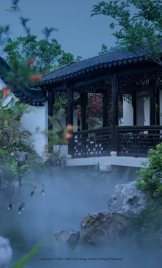 一个小建筑在花园中的池塘中央