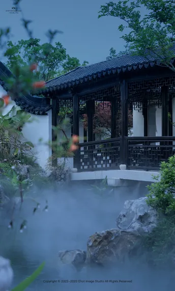 一个小建筑在花园中的池塘中央