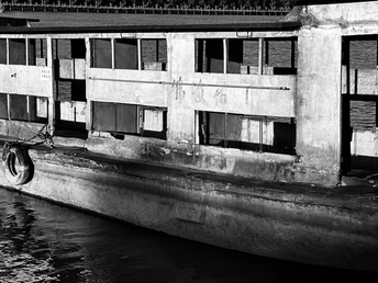 停泊在靠近一座老建筑的水域中的小船