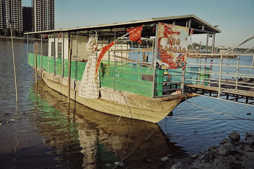 靠近城市岸边的广阔水域中的一艘小船